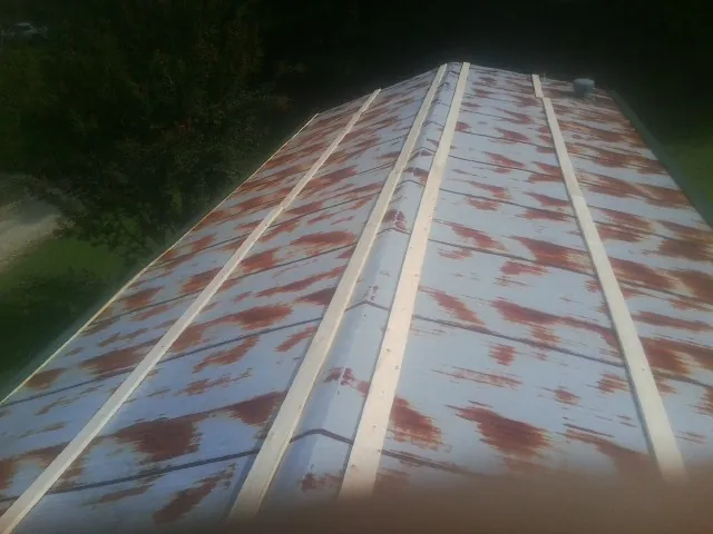 Rusted metal roof panels with new wood purlins before replacement — Storm Damage Roof Repair in Wedgefield by Roofing Brothers